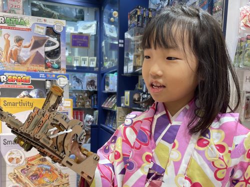 ロボットハンドを手にはめて遊んでいる小学生の女の子の様子