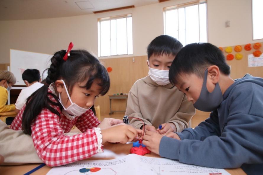 ひかる車で発明をしている3人の子どもたち